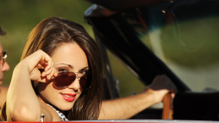 Portrait of a charming young woman in a convertible car