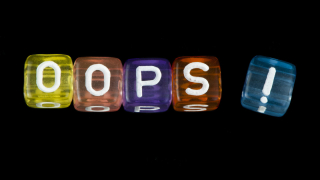 Word Oops. Black isolated cubes. Studio shot